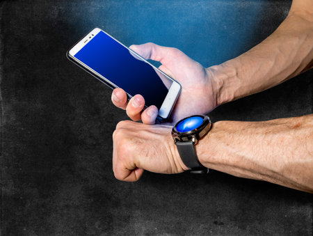 Man synchronizes his smartphone and smart watch on his hand