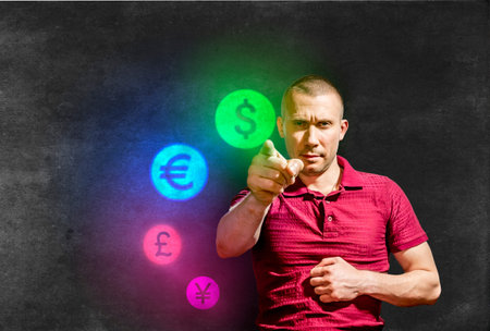 A stern Man points with his index finger at the pictograms of world currencies on the background of...