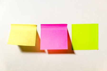 Multi-colored square  notes pasted on a white wall in the office
