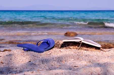 Book and sandals at the beachの写真素材