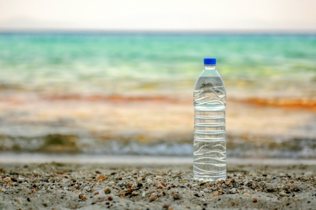 Bottle of natural water placed at the beach near the seaの写真素材