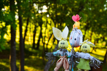 scarecrow toys attached like decoration in the backyard with trees behind with beautiful contrastの写真素材