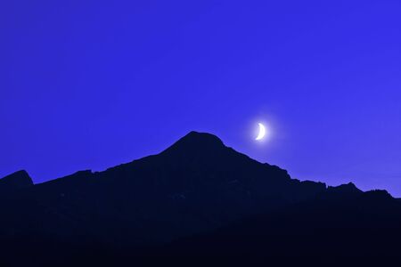 the moon over a peakの写真素材