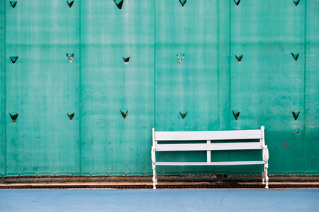 White field chair in tennis court with green plastic background.の写真素材
