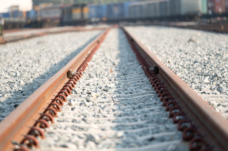 Train tracks in Thailand with blurred train car in background.