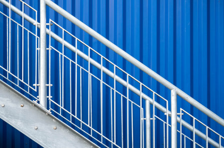 Metal stairs with blue wall in background.の写真素材