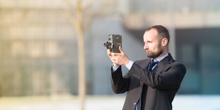 Businessman outdoor with a vintage film cameraの写真素材