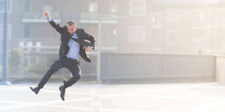 Dynamic businessman jumping outdoor in the cityの写真素材