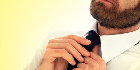 Elegant businessman adjusting his tieの写真素材