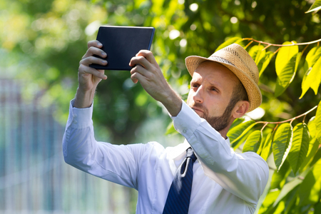 Digital farmer checking his field with a tabletの写真素材