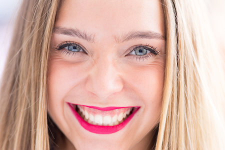 Happy young girl outdoors, front portrait photo with defocused copy space backgroundの写真素材