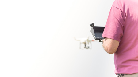 Pilot with his small drone flying outdoors, technology concepts, copy space photoの写真素材