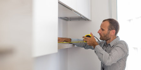 Architect taking measures of a brand new kitchen. Home style and design conceptsの写真素材