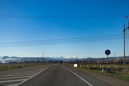 Driving on the interstate in early spring with snow capped mountains in the background.