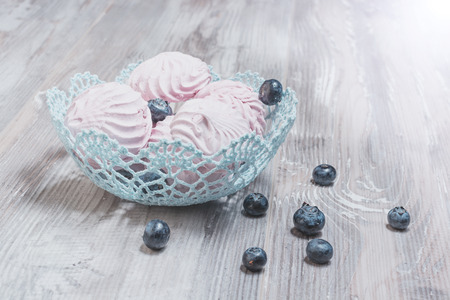 Meringue decorated with blueberries on wood backgroundの写真素材
