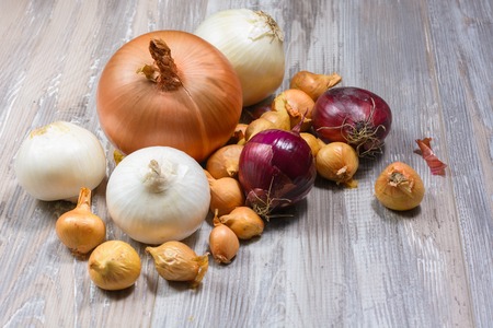 white, red, gold onionon on wooden background. Selective focus.の写真素材