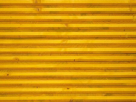 Stacked yellow wood panels forming a parallel patternの写真素材
