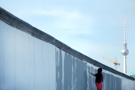 painter painting the berlin wall in front of tv-towerの写真素材