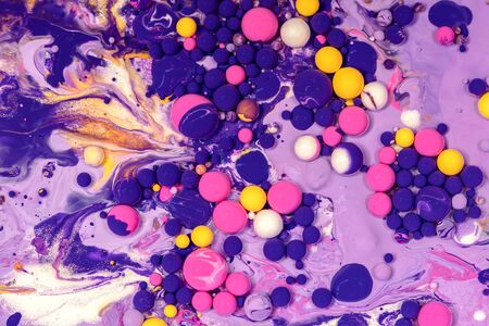 Acrylic paint balls abstract texture. Purple, blue, pink and yellow liquids mix. Creative multicolor background. Bright colors fluid, flowing wallpaper design. Mixed pigments violet backdropの写真素材