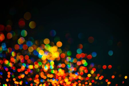 Multicolor glitter raster background. Abstract shimmering red circles on deep purple backdrop. Vibrant bokeh lights effect festive illustration. Overlapping glowing and twinkling spotsの写真素材