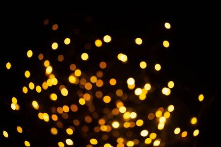 Golden sparkles raster festive background. Bokeh lights with bright shiny effect illustration. Overlapping glowing and twinkling spots decorative backdrop. Abstract glittering circlesの写真素材