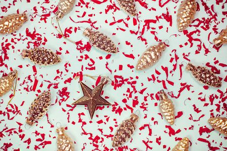 New Year elegant decorative background. Golden glass fir tree festive ornaments. Vintage Xmas pine cones and star shaped baubles with red paper confetti. Horizontal Christmas beautiful backdropの写真素材