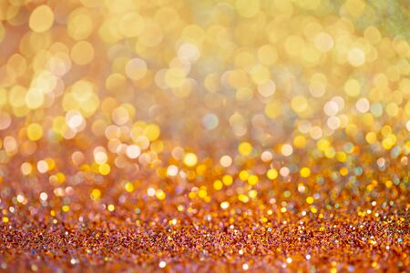 Golden sparkles festive background. Bokeh lights with bright shiny effect illustration. Overlapping glowing and twinkling spots decorative backdrop. Abstract glittering circlesの写真素材