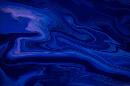Fluid art texture. Abstract backdrop with mixing paint effect. Liquid acrylic artwork with trendy mixed paints. Classic blue color of the year 2020. Blue, black and white overflowing colorsの写真素材
