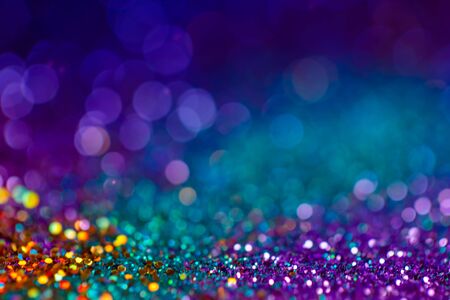Decoration twinkle lights background, abstract blurred backdrop with circles,modern design overlay with sparkling glimmers. Blue, purple, golden and green backdrop glittering sparks with glow effectの写真素材