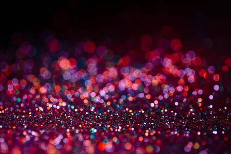 Decoration bokeh glitters background, abstract shiny backdrop with circles,modern design overlay with sparkling glimmers. Black, pink and orange backdrop glittering sparks with glow effectの写真素材