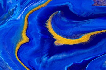 Fluid art texture. Abstract backdrop with swirling paint effect. Liquid acrylic artwork that flows and splashes. Classic blue color of the year 2020. Blue, indigo and golden overflowing colorsの写真素材