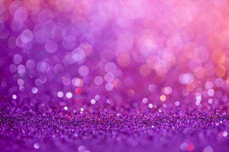 Decoration bokeh glitters background, abstract blurred backdrop with circles,modern design overlay with sparkling glimmers. Purple, pink and golden backdrop glittering sparks with glow effectの写真素材