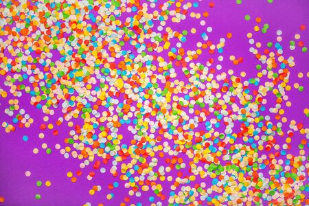 Purple background with vivid confetti. Colorful abstract backdrop with scattered paper circles. Beautiful decor for the party. Festive composition for celebration. View from above. Flat layの写真素材
