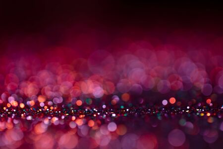 Festive twinkle glitters background, abstract glowing backdrop with circles,modern design wallpaper with sparkling glimmers. Purple, red and black backdrop glittering sparks with glow effectの写真素材