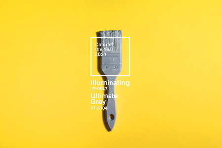 Gray brush on yellow background, trend and mod colors of 2021 year. Minimalistic vibrant picture for article, banner or posterの写真素材