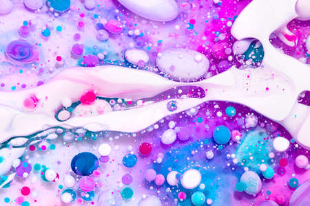 Fluid art texture. Abstract backdrop with iridescent paint effect. Liquid acrylic picture that flowing bubbles. Mixed paints for website background. Pink, blue and white overflowing colorsの写真素材