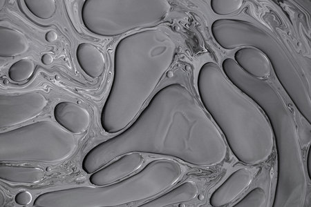 Fluid art moon texture. Abstract backdrop with swirling paint effect. Liquid acrylic picture that flowing bubbles. Mixed paints for background or poster. Black, white and gray overflowing colorsの写真素材