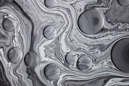 Fluid art moon texture. Abstract backdrop with swirling paint effect. Liquid acrylic picture that flowing bubbles. Mixed paints for background or poster. Black, white and gray overflowing colorsの写真素材