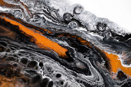 Fluid art texture. Abstract background with iridescent paint effect. Liquid acrylic artwork with flows and splashes. Mixed paints for baner or wallpaper. Black, golden and white overflowing colorsの写真素材