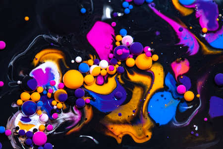 Fluid art texture. Abstract background with swirling paint effect. Liquid acrylic picture that flowing bubbles. Mixed paints for background or poster. Black and bright overflowing colorsの写真素材
