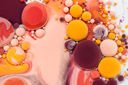 Fluid art texture. Abstract backdrop with iridescent paint effect. Liquid acrylic artwork with flowing bubbles. Mixed paints for background or poster. Beige, red, orange and brown overflowing colorsの写真素材