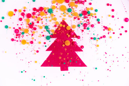 Christmas tree with overflowing colors. Happy new year background with liquid paint effect, colorful bubbles and vibrant glitters. Festive liquid backdrop for winter holiday celebration.の写真素材
