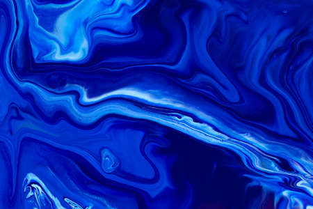 Fluid art texture. Backdrop with abstract mixing paint effect. Liquid acrylic picture that flows and splashes. Classic blue color of the year 2020. Blue, white and indigo overflowing colors.の写真素材