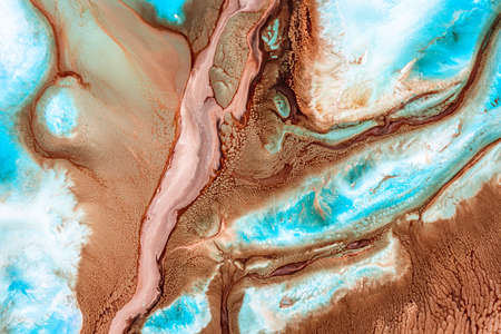 Liquid art texture with pouring colors. Fluid backdrop with flows and cells, waves. Abstract background with splatter inks. Blue, brown and white colors mixing on macro photography picture.の写真素材