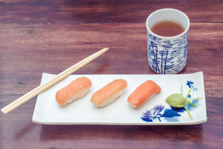 delicious sushi served on dish on wooden table with tea close-upの写真素材