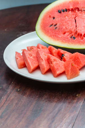 Closeup of watermelon whole and slice on wooden tableの写真素材