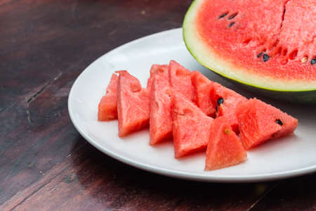 Closeup of watermelon whole and slice on wooden tableの写真素材