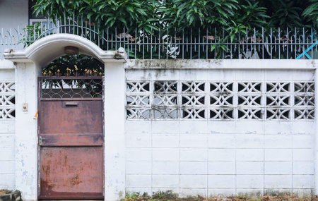 Old metal iron rust door with old cement wall , plastered wall background and textureの写真素材