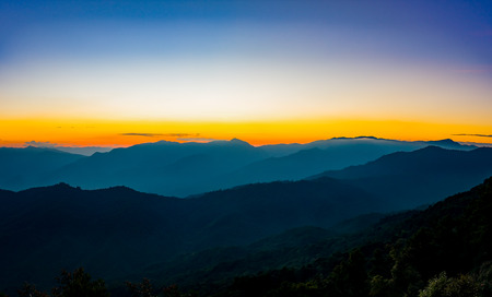 Sunset in the mountains landscape with sunny at Doi Pha Hom Pok, the northernmost national park in Thailand, The tallest peak is Doi Pha Hom Pok at 2,285 metres, the second highest in Thailandの写真素材