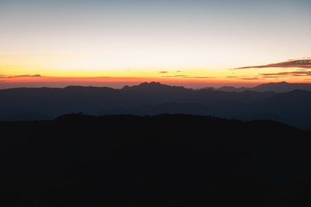 Sunset over black mountains in the fog, Mountain layer backgroundの写真素材